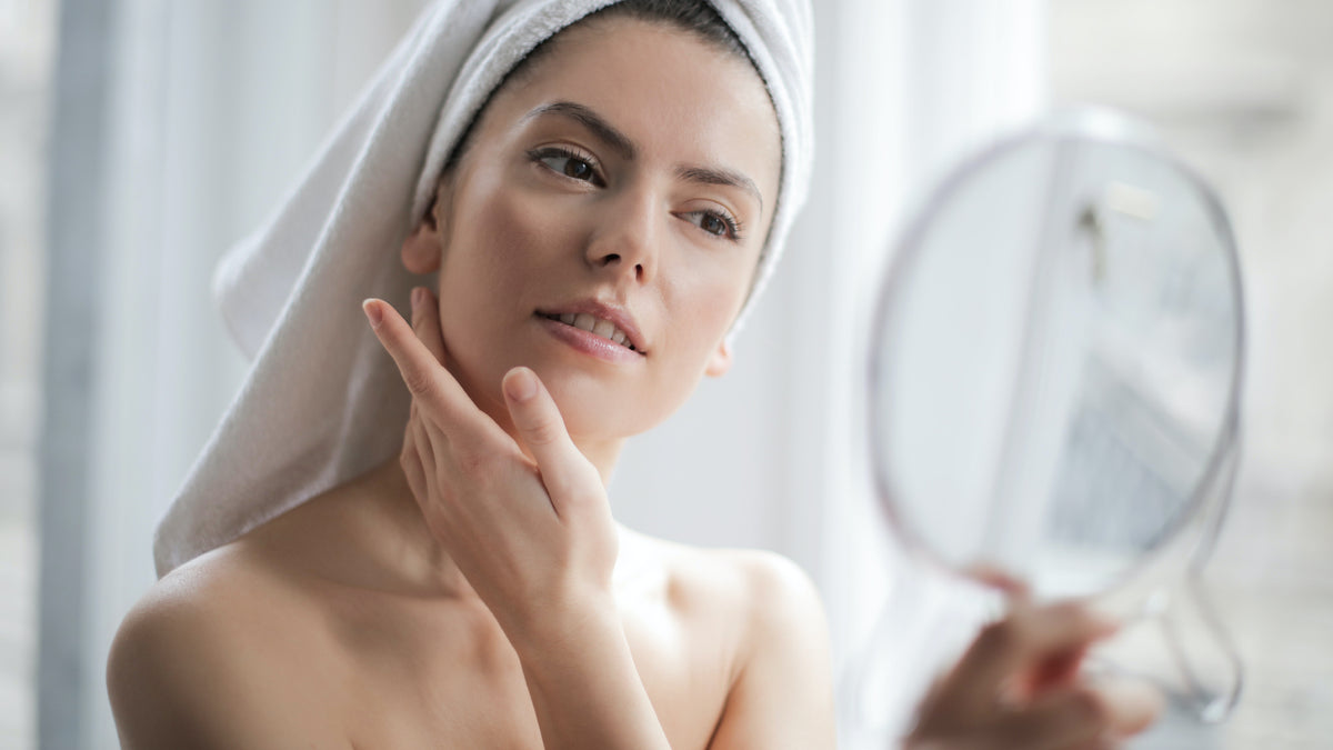 woman-looking-in-mirror-touching-face