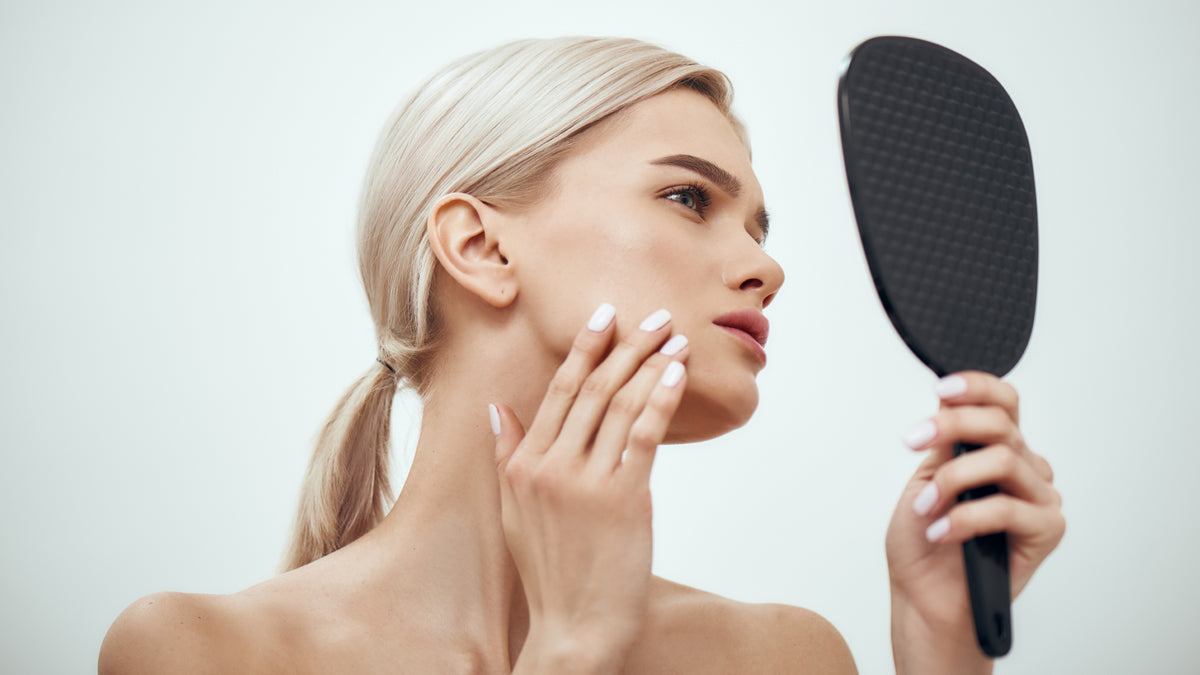 Blonde woman with great skin looking in the mirror