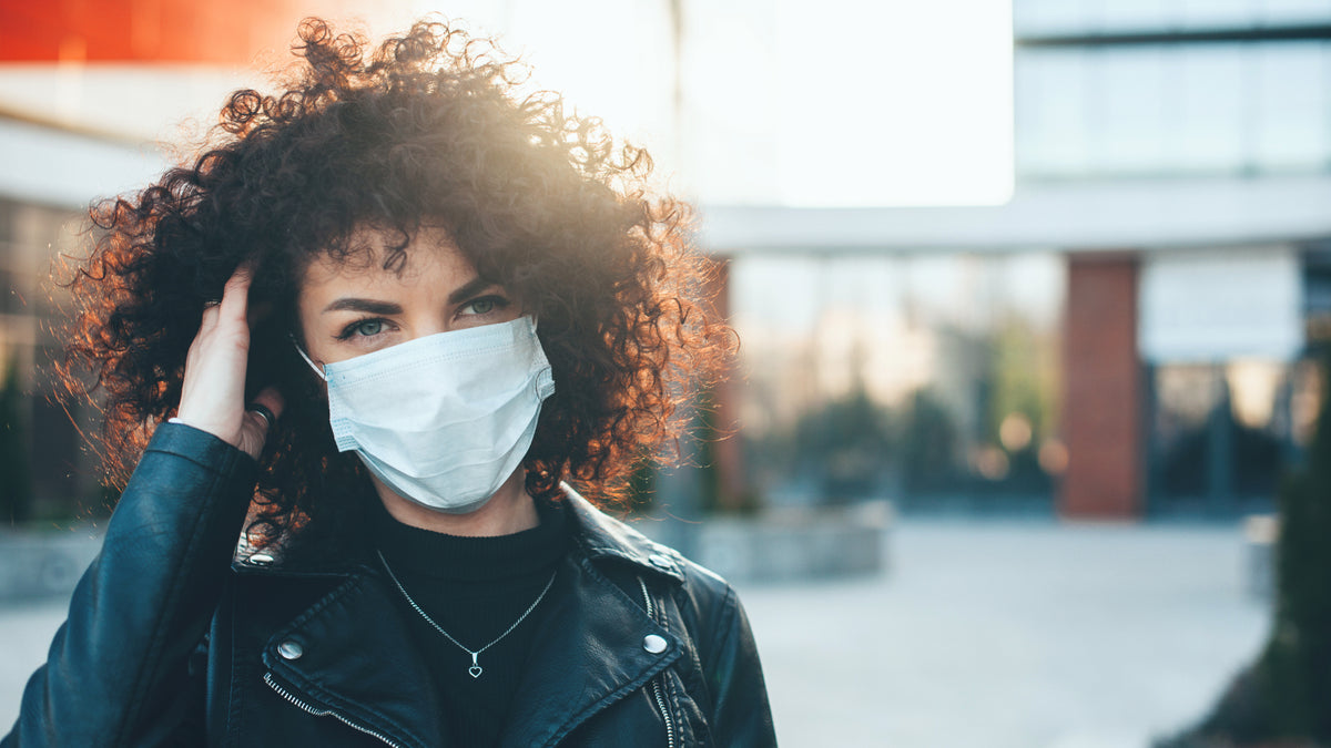 curly haired brunette girl wearing protective face mask