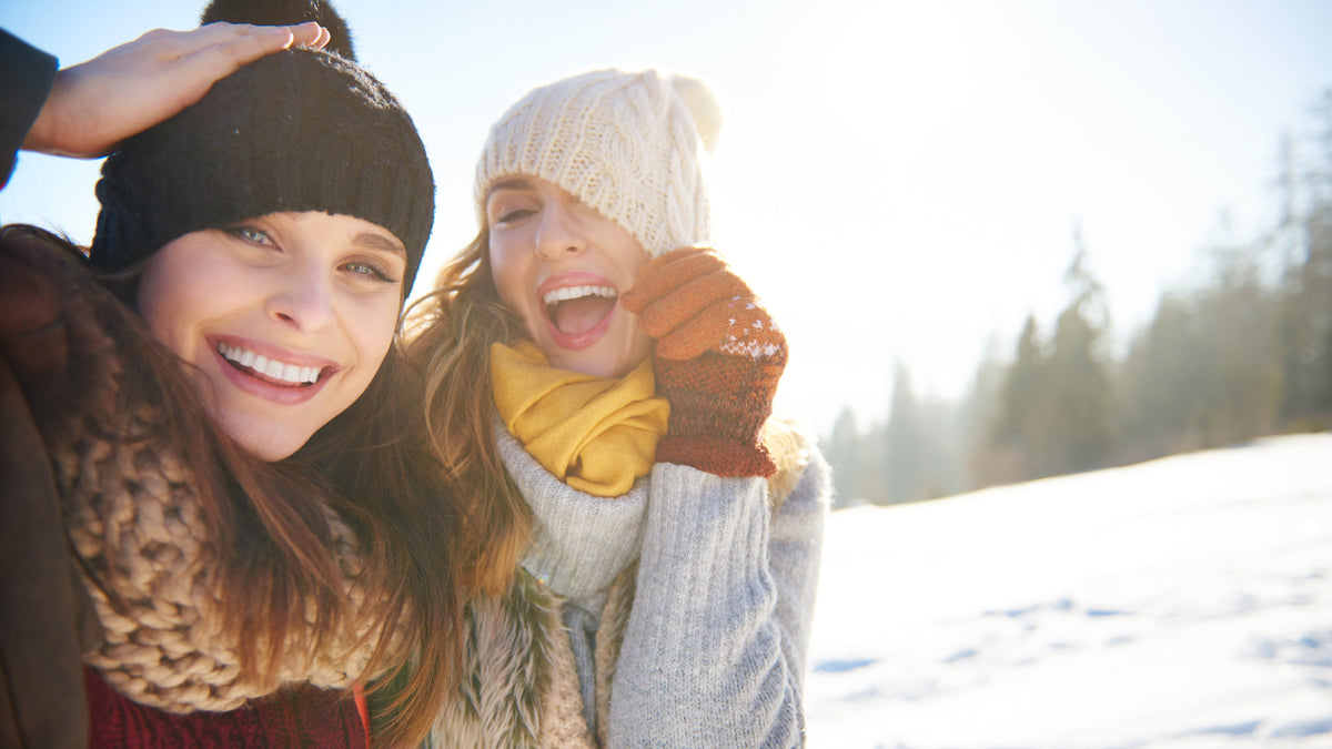 Two girlfriends laughing in the snow