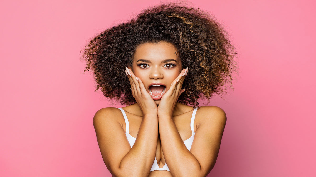 Black woman holding head looking stressed at computer screen