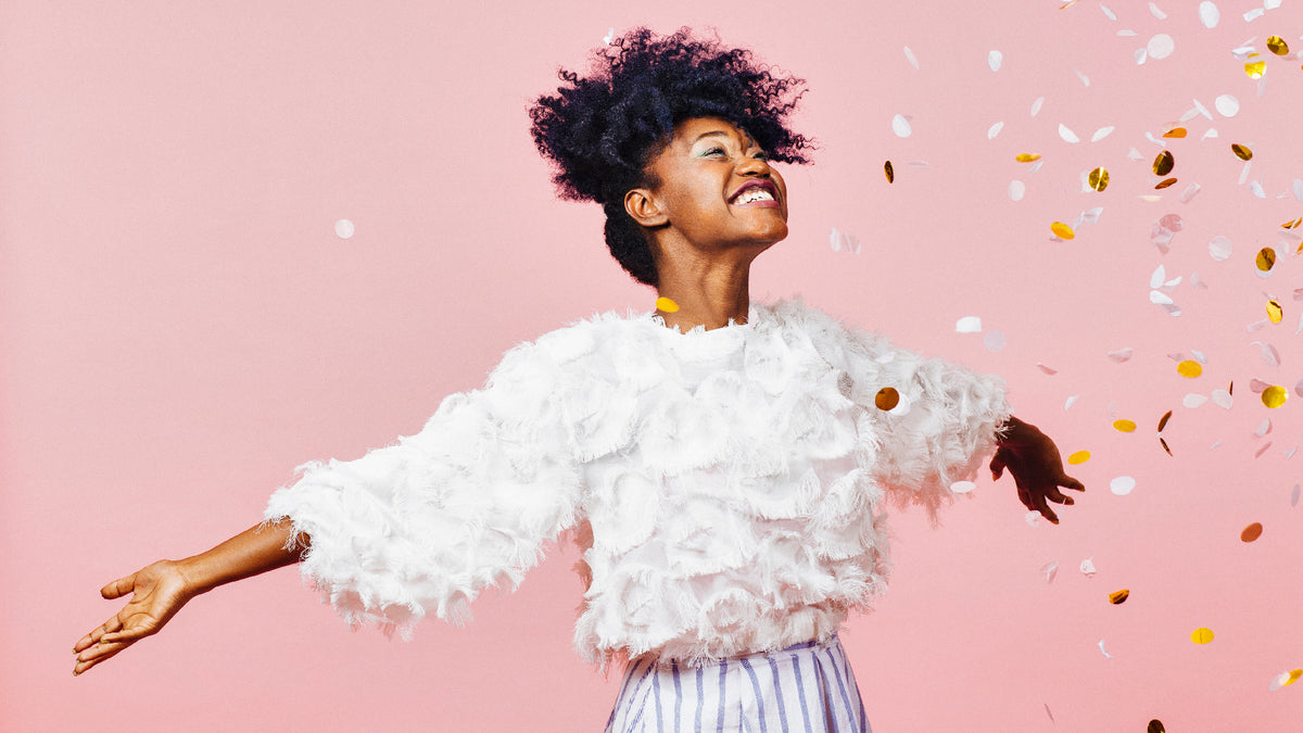 Beautiful black woman smiling cheering and celebrating with arms open wide