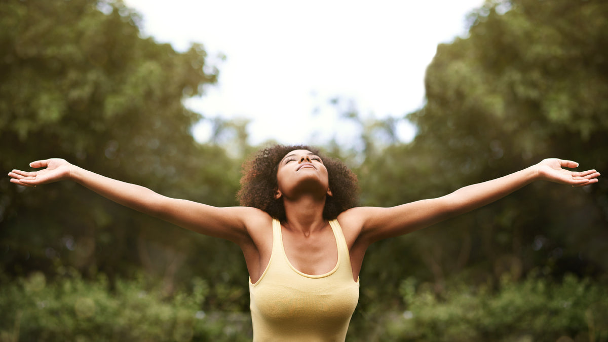young black woman outside enjoying fresh air with arms open