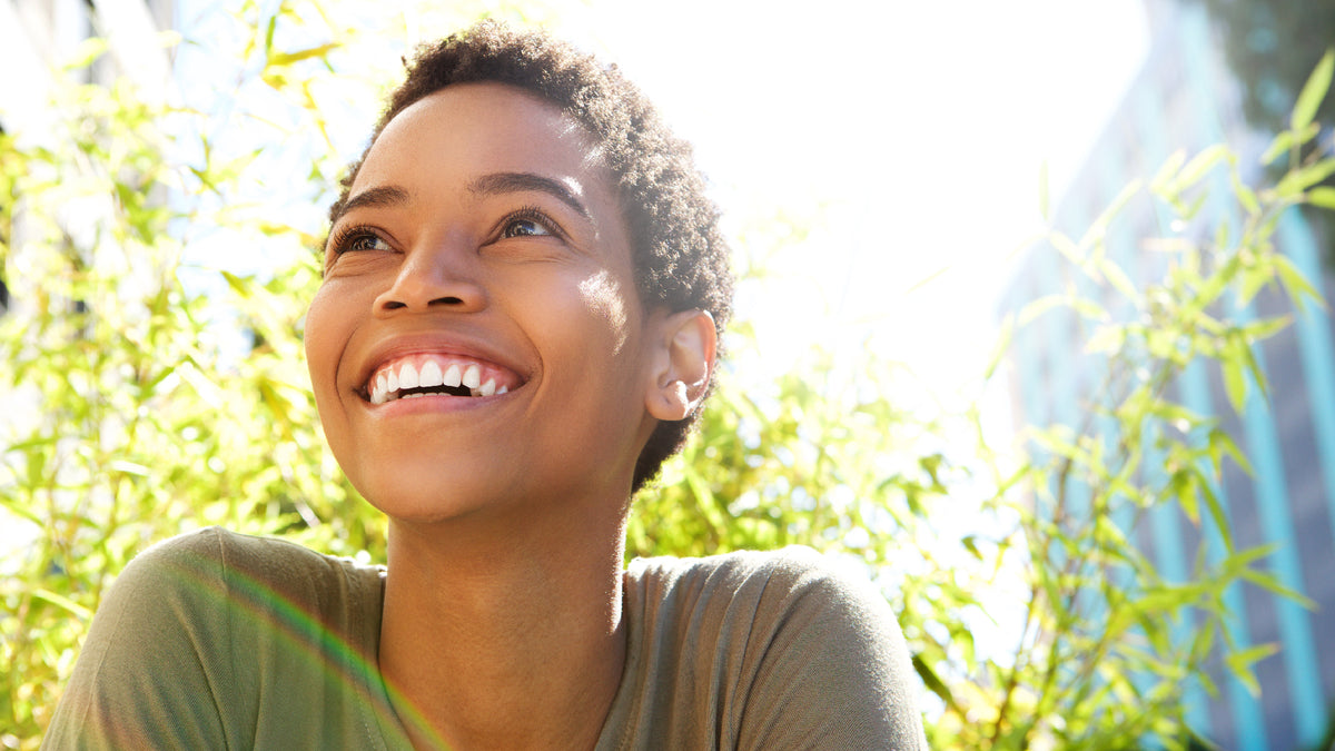 black girl with short hair smiling in sunshine