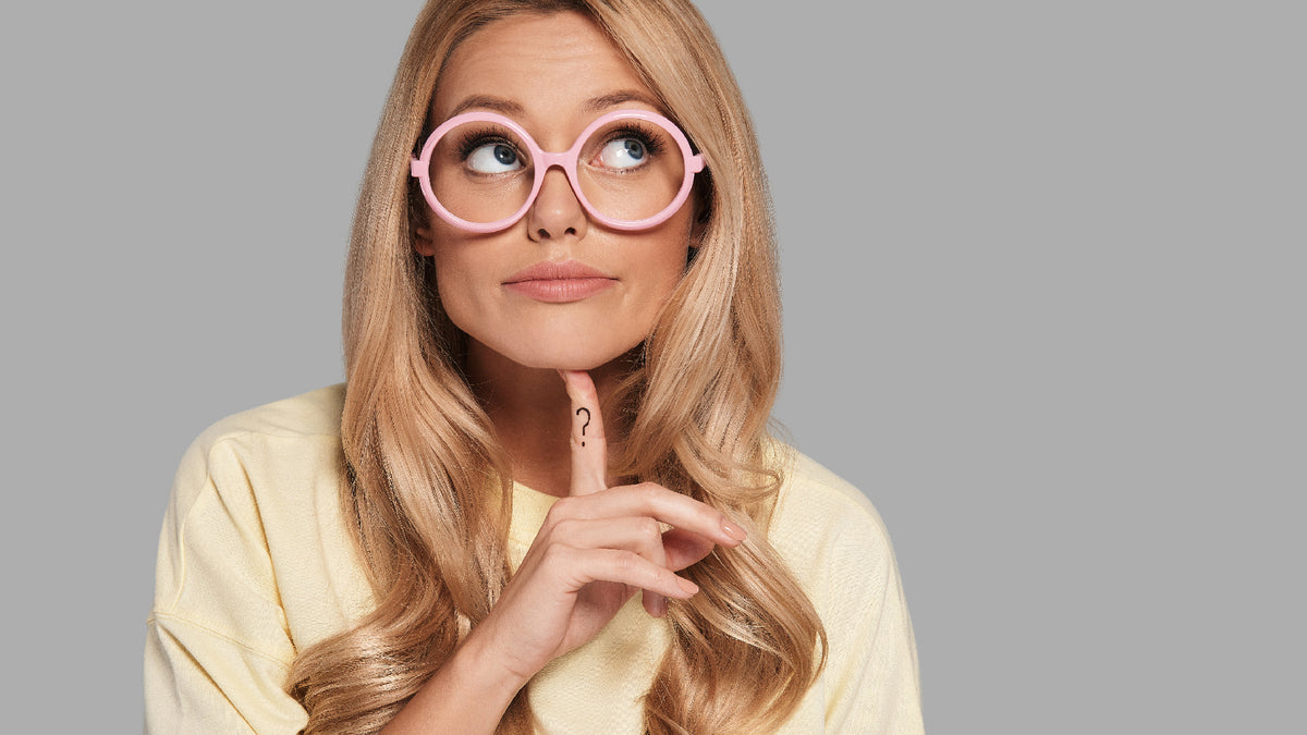 blonde girl with pink glasses looking confused asking questions