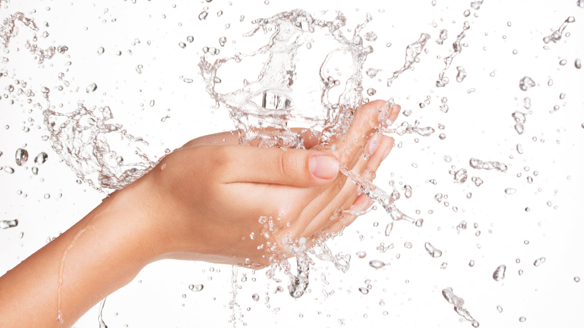 woman's hands catching falling water