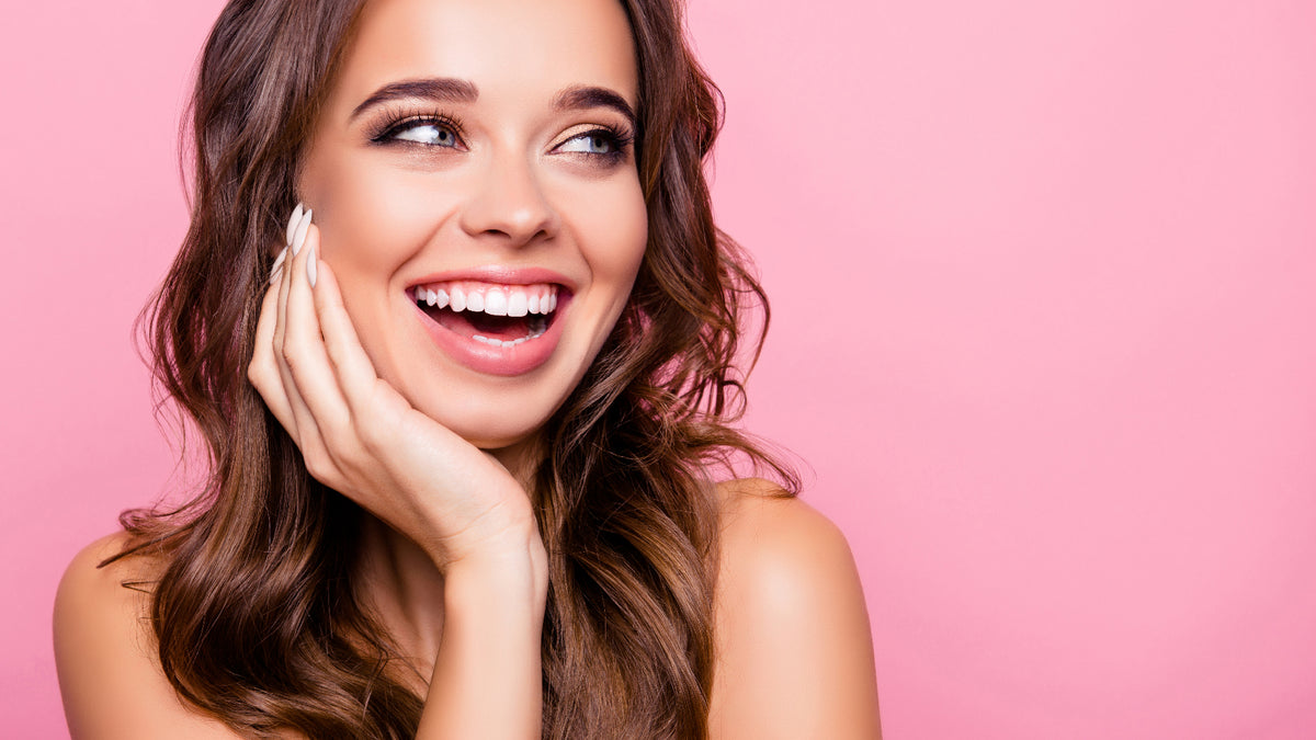 Gorgeous brunette girl laughing on pink background