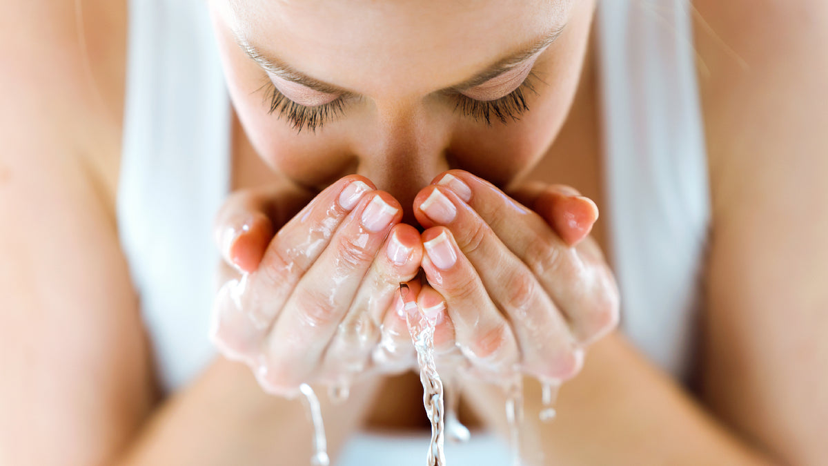 close-up of white woman splashing face with water