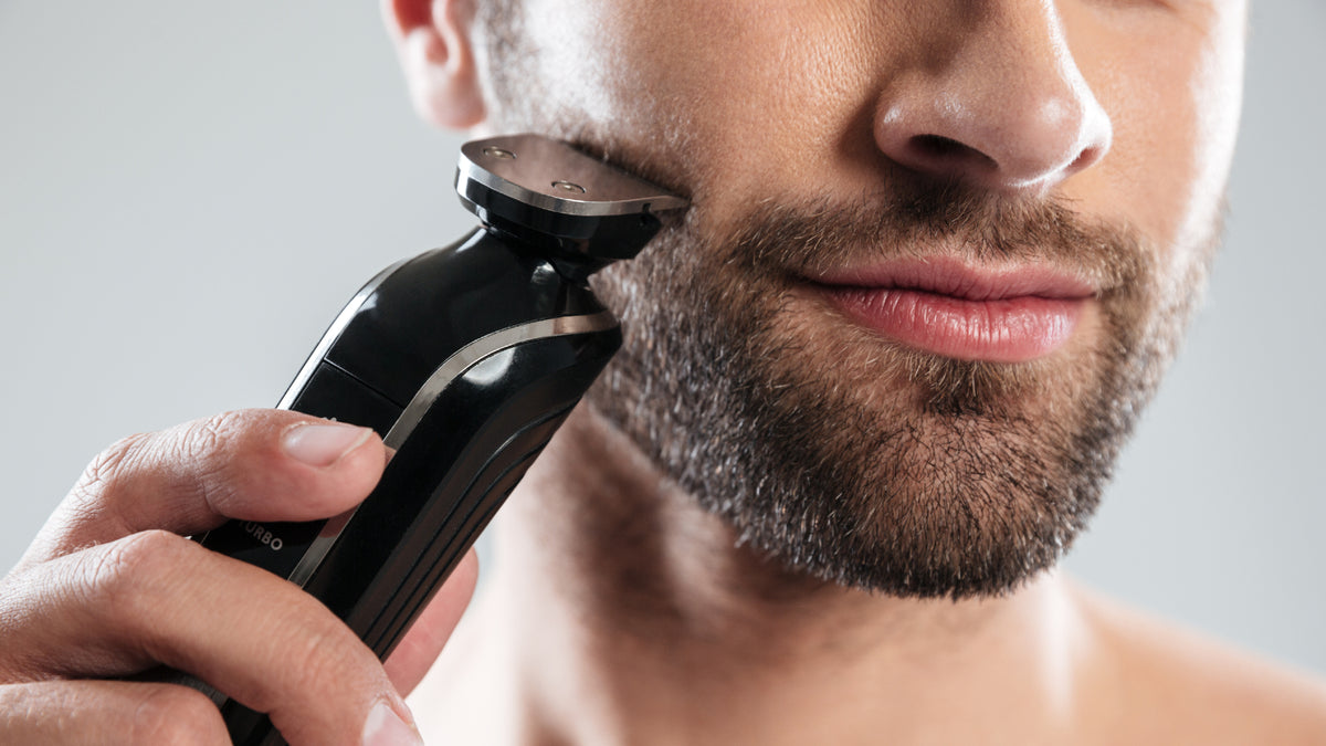 white man with facial hair shaving his beard