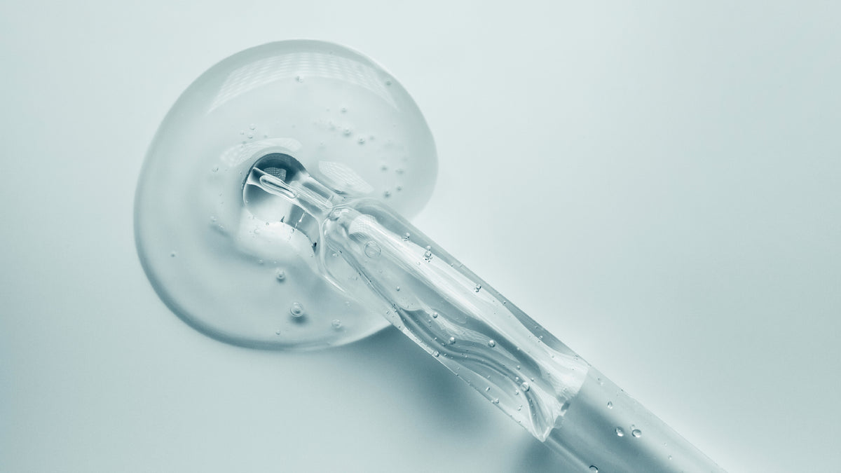 pipette with drop of serum on pale blue background