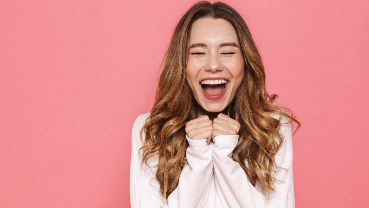 girl screaming and laughing on pink background