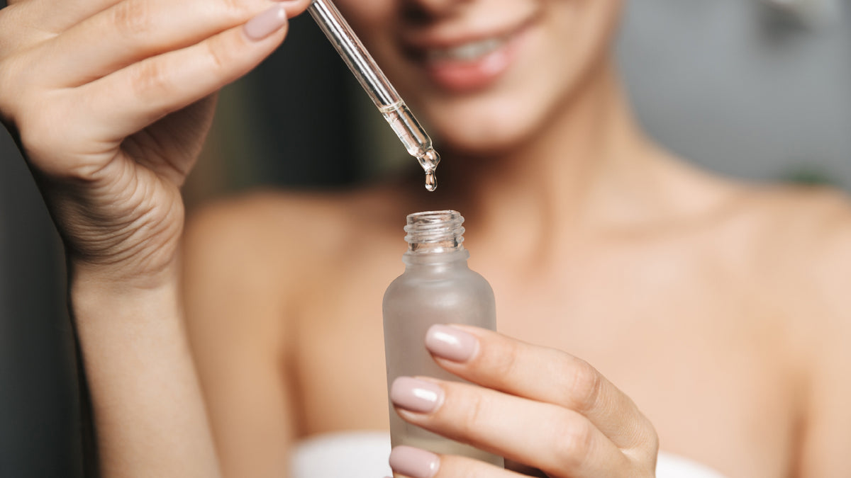 close-up bottle of serum with girl in the background