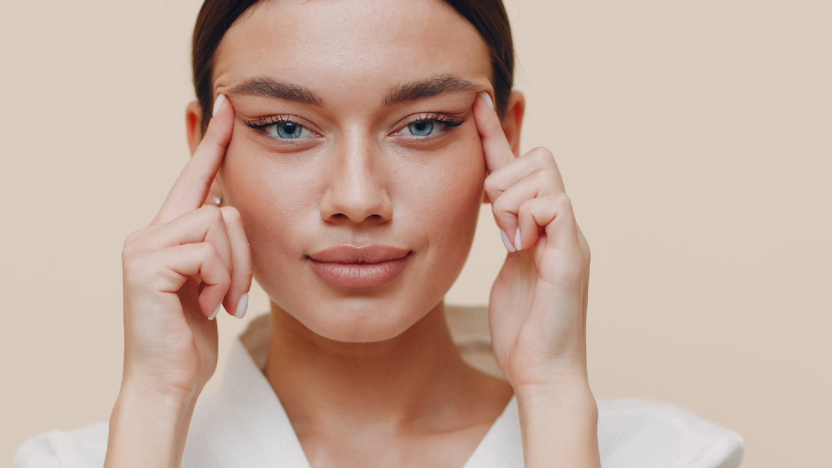 brunette girl on beige background performing facial massage