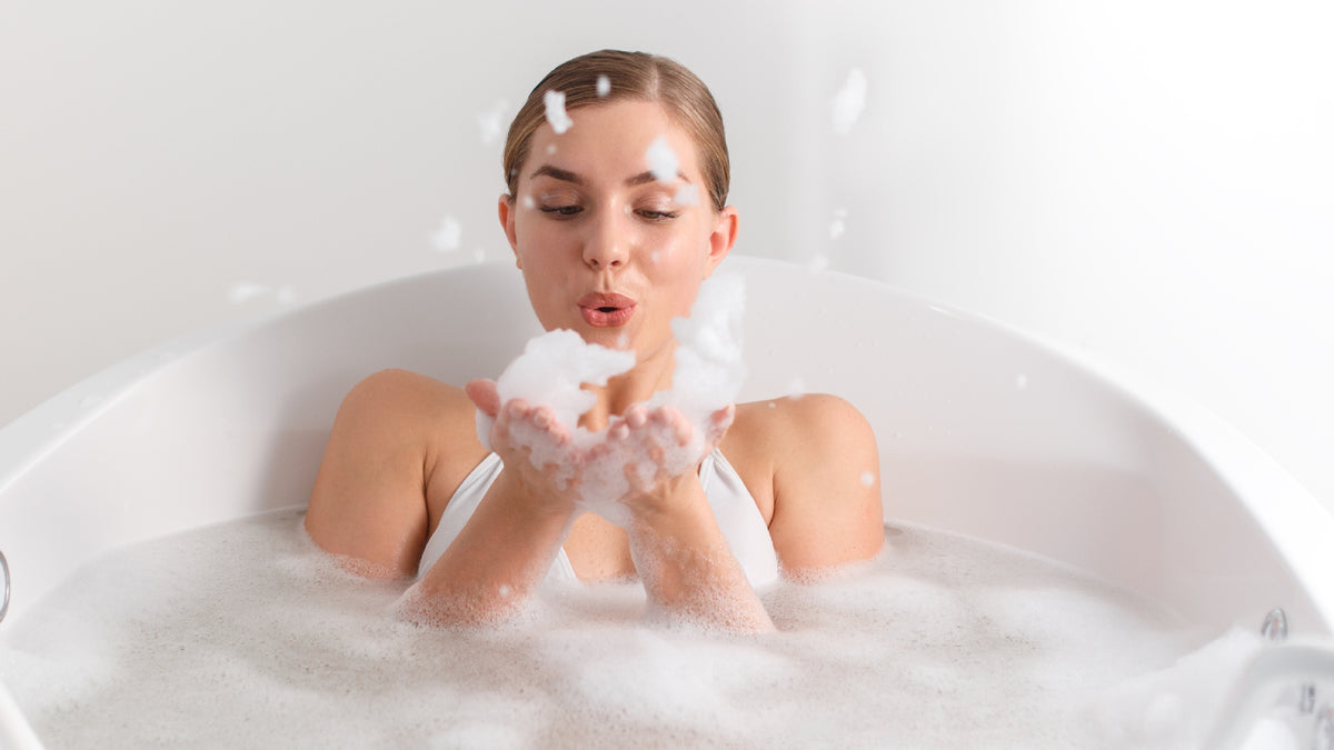 white girl in the bath blowing bubbles