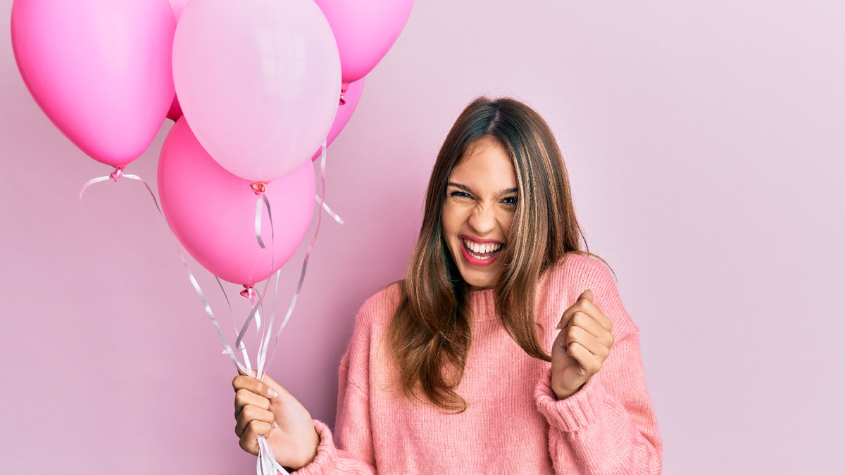 brunette girl celebrating with pink balloons