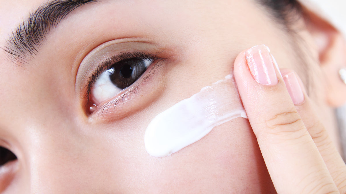 Close-up image of girl applying face cream to skin