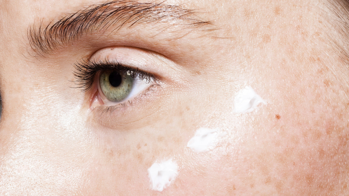 close up of woman with eye cream around one eye