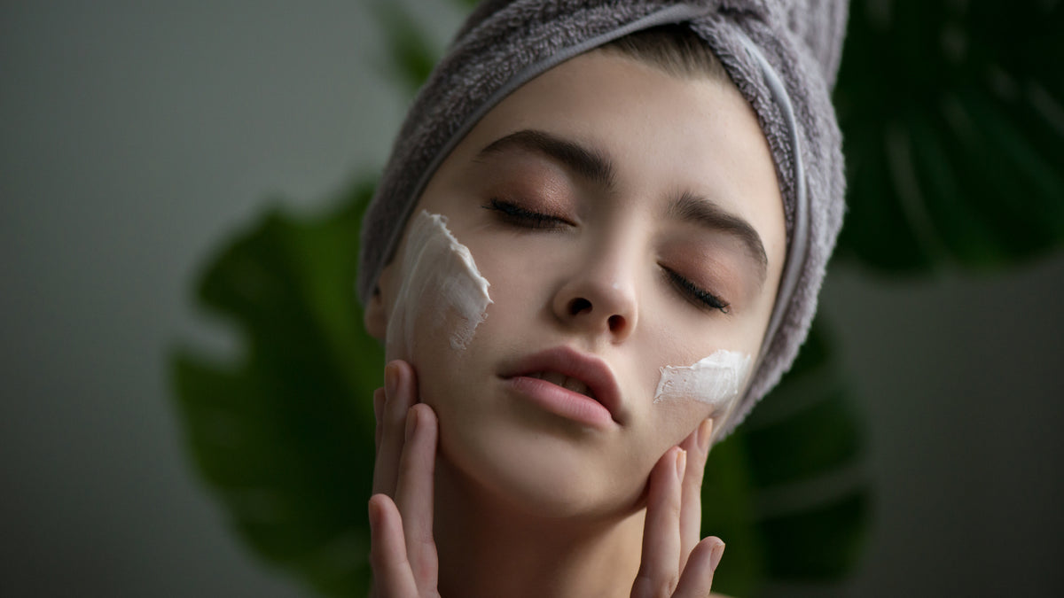 white girl with great skin applying moisturizer to cheekss