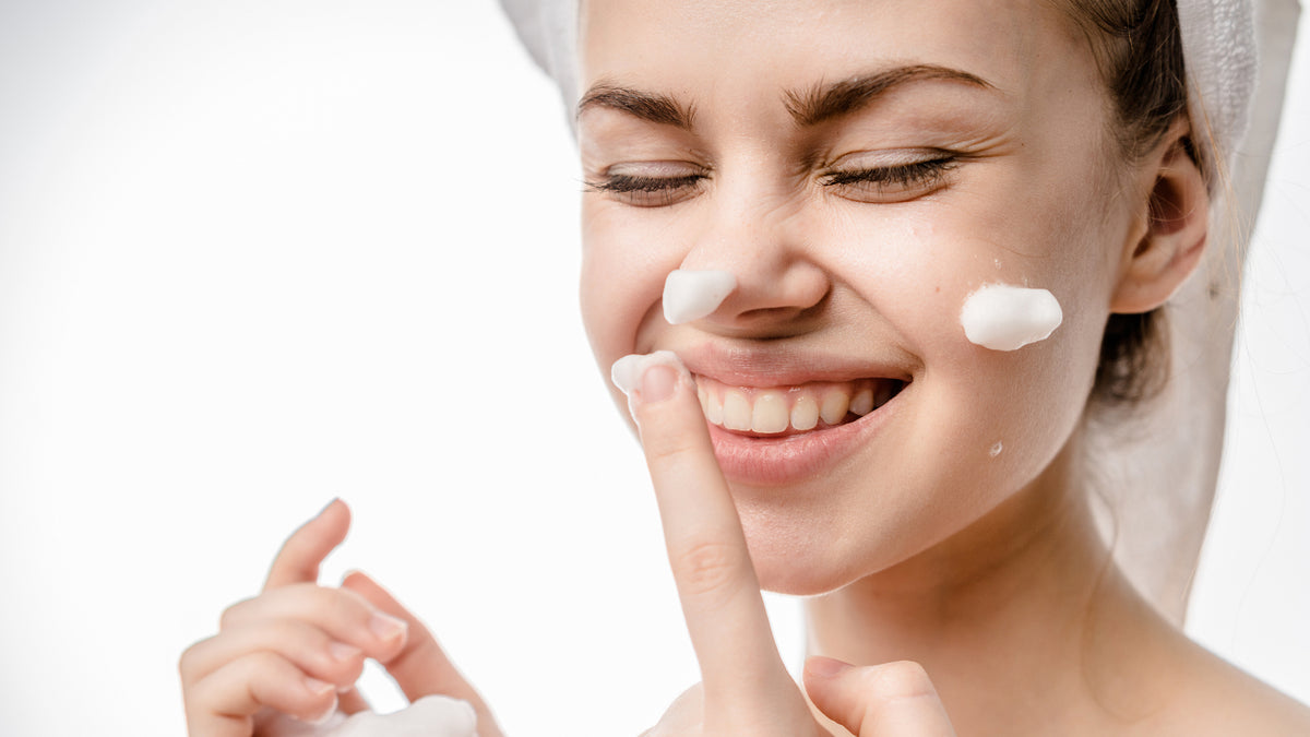 white girl applying face cream and laughing