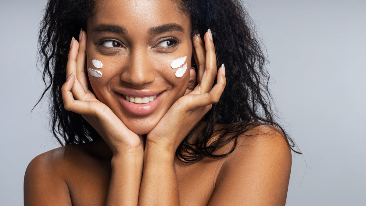 beautiful black woman with face cream on her cheeks