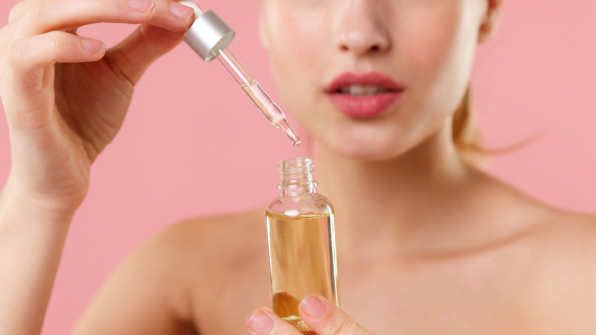 close-up of white girl looking at bottle of skin serum
