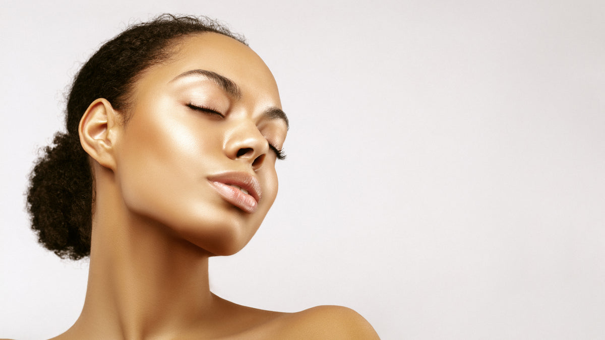Beautiful black woman on gray background with glowing skin