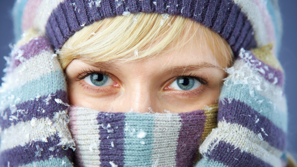 blonde woman covering up with hat and scarf in winter