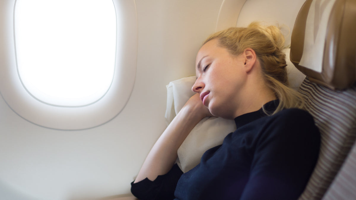 young blond woman asleep on a plane