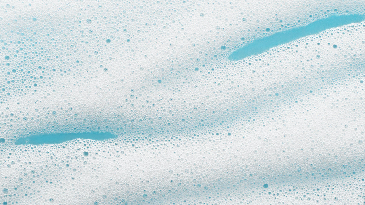 big close-up of foaming cleanser on blue background
