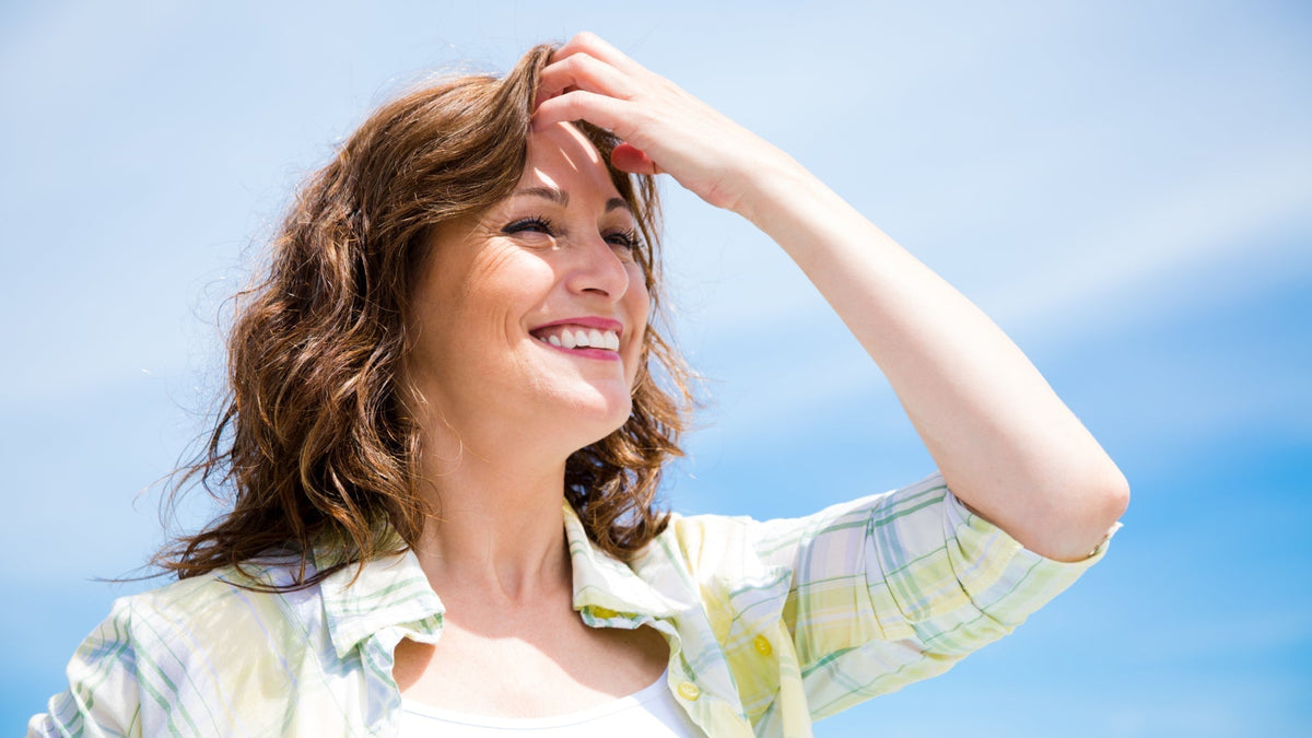 middle-aged brunette woman smiling outside in sunshine