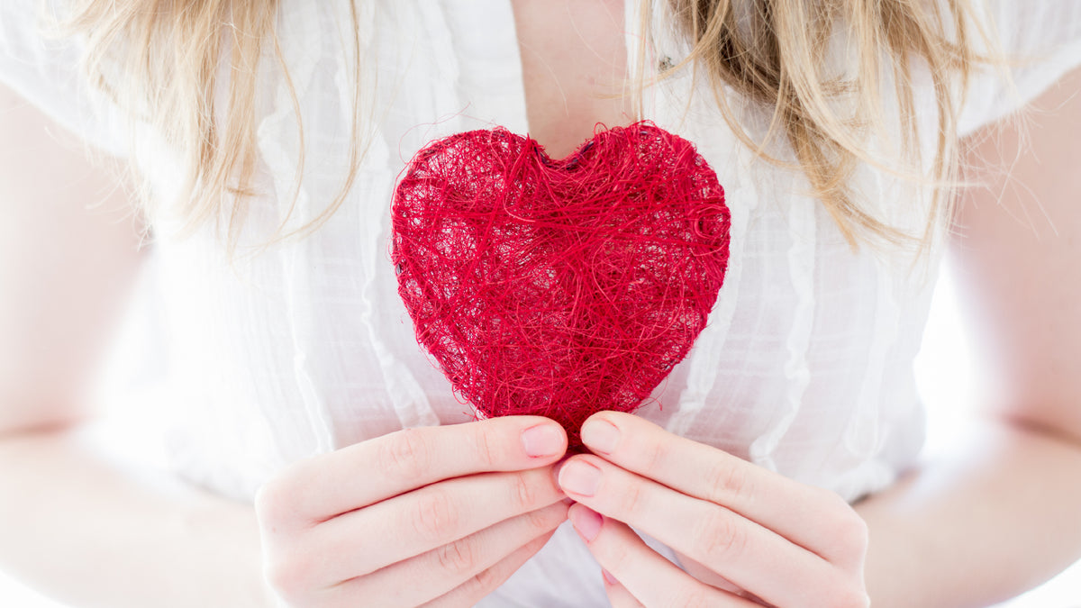 close-up of blonde woman holding love heart