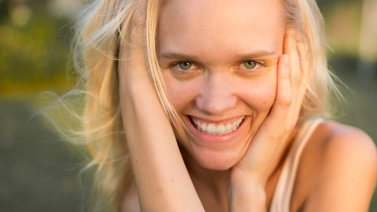 beautiful blond woman with great skin, smiling, outside