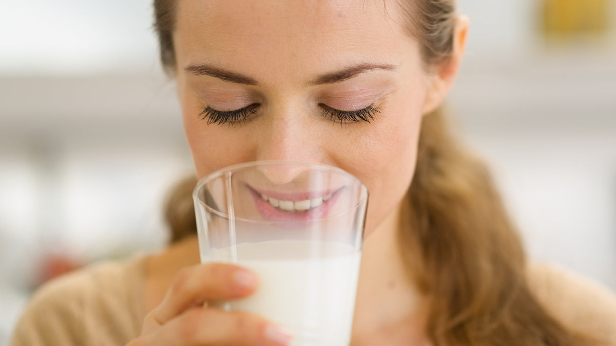 Blonde girl with great skin smiling and drinking milk