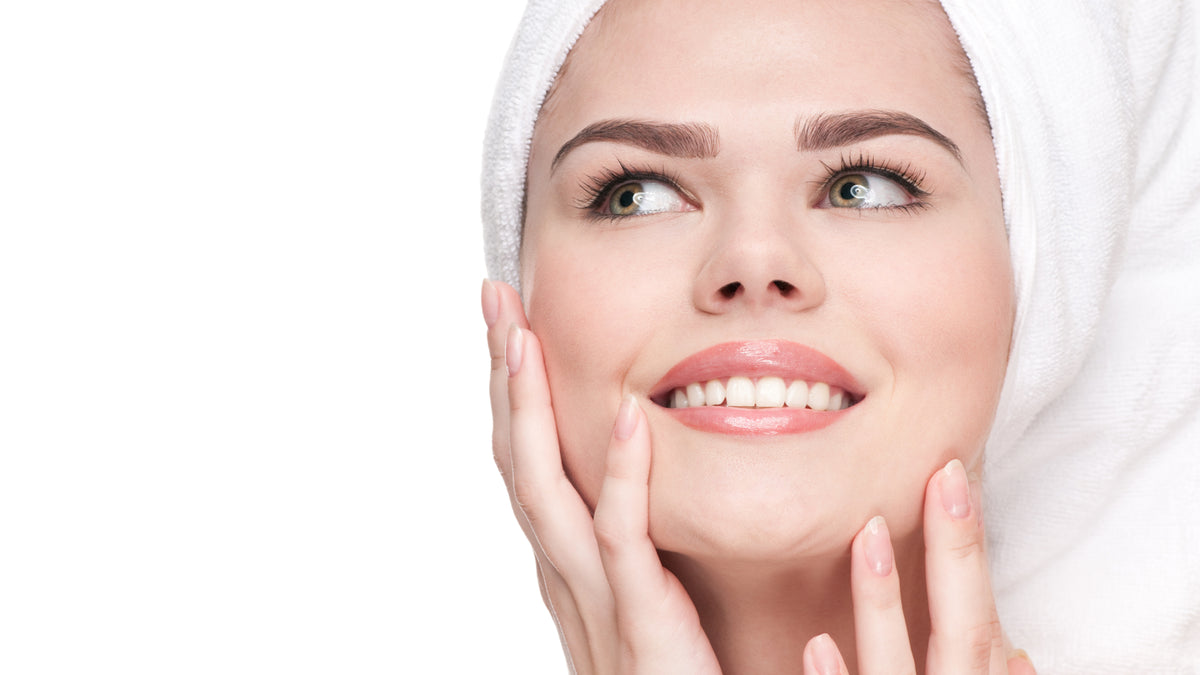 close up young brunette woman with towel on head and great skin