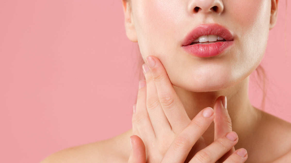 close-up of white girl on pink background touching skin