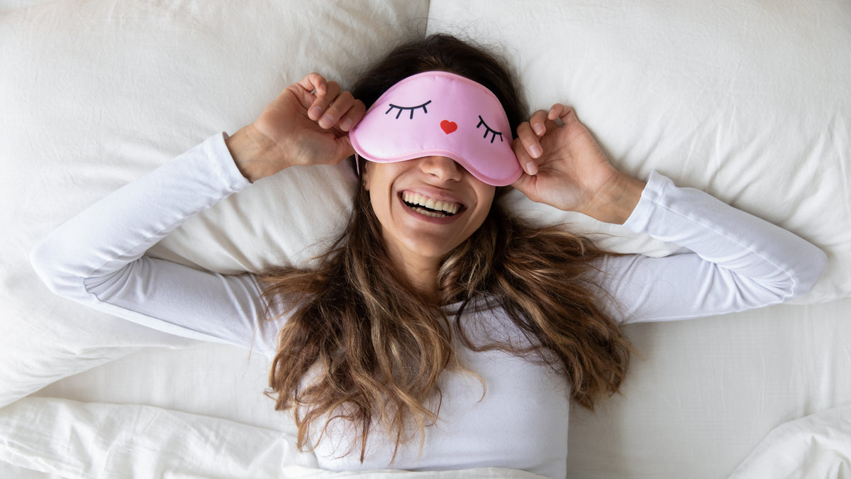 young woman in bed with eye mask