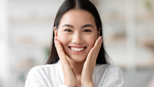 young asian woman smiling while touching face