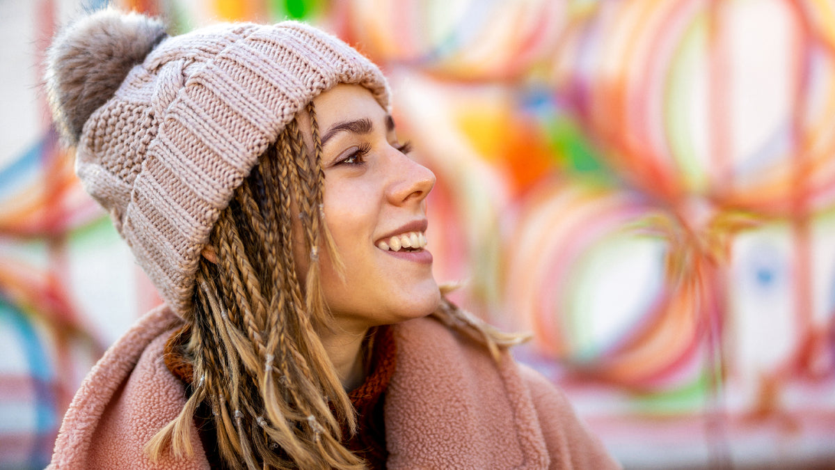 Happy smiling girl with great skin wearing winter beanie