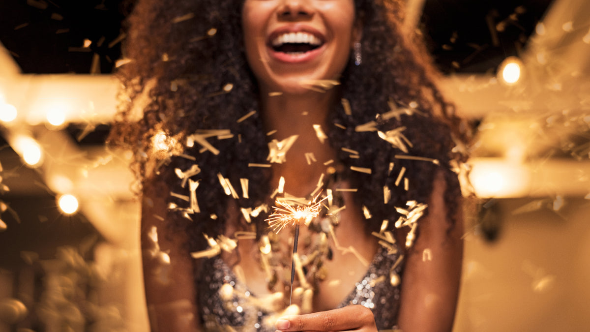 woman laughing and celebrating holding sparkler